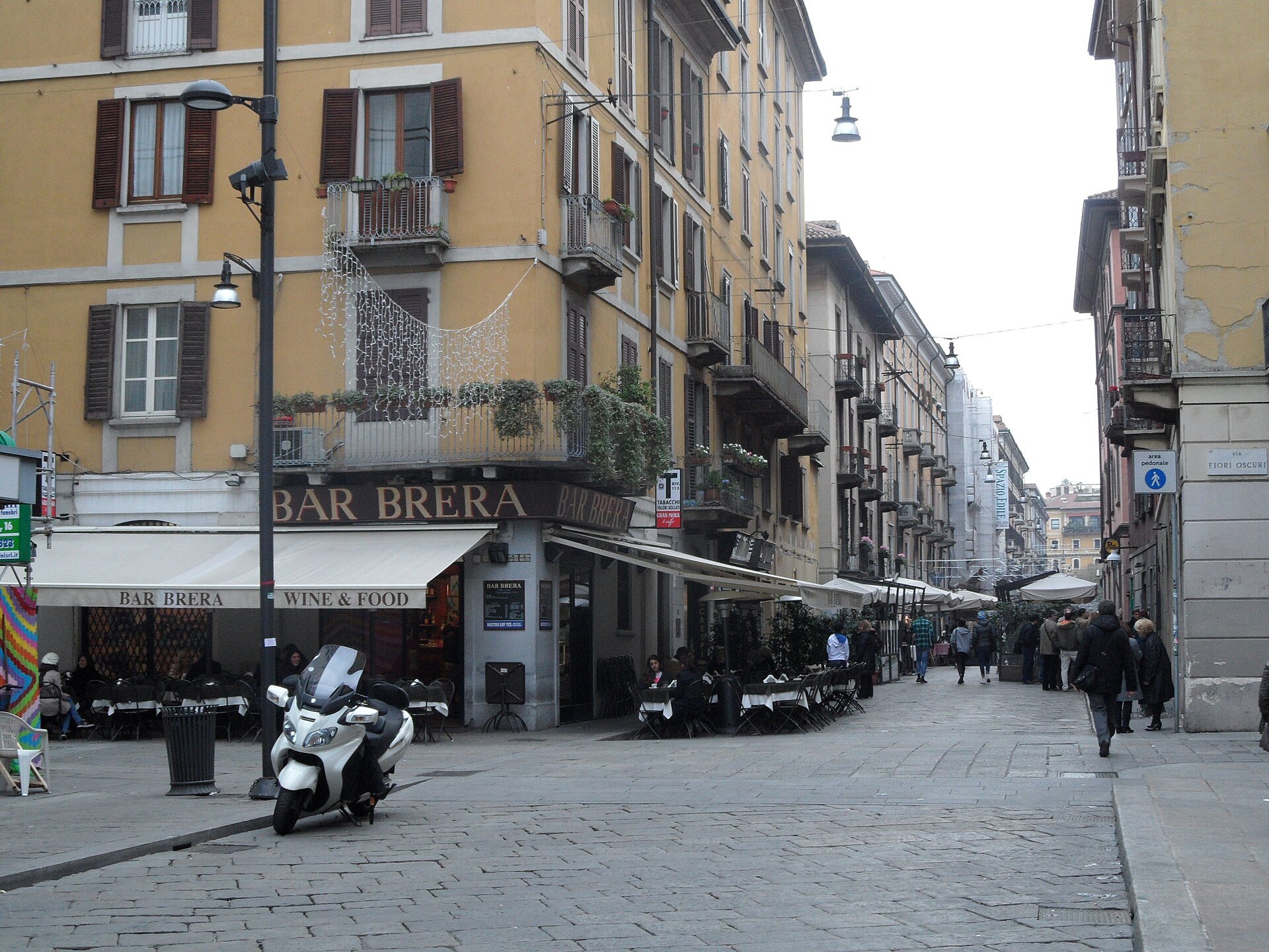 A corner bar in Brera with scooters parked outside and the street running past