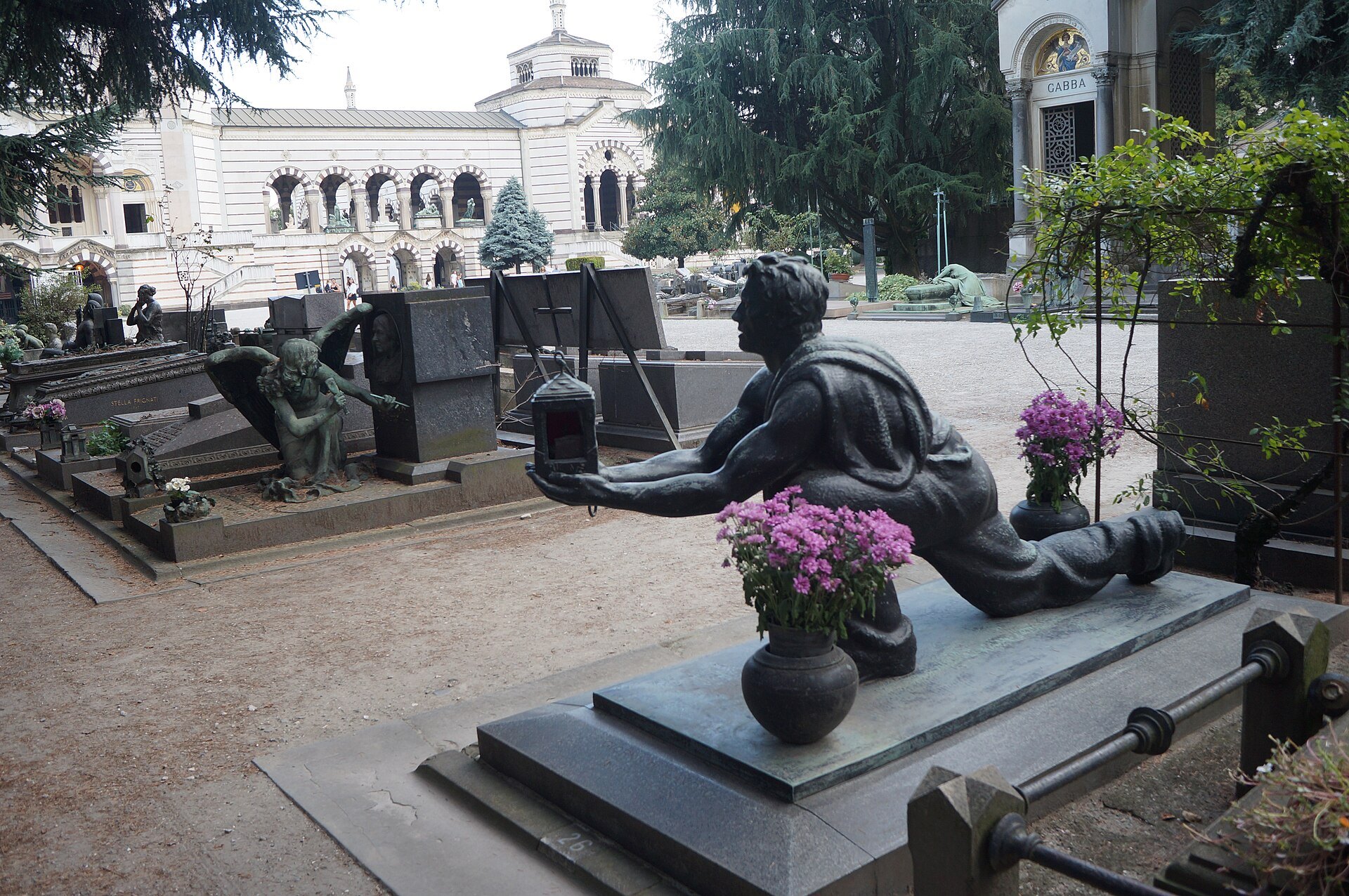 An avenue of monuments at the Monumental Cemetery with a bronze figure in the foreground