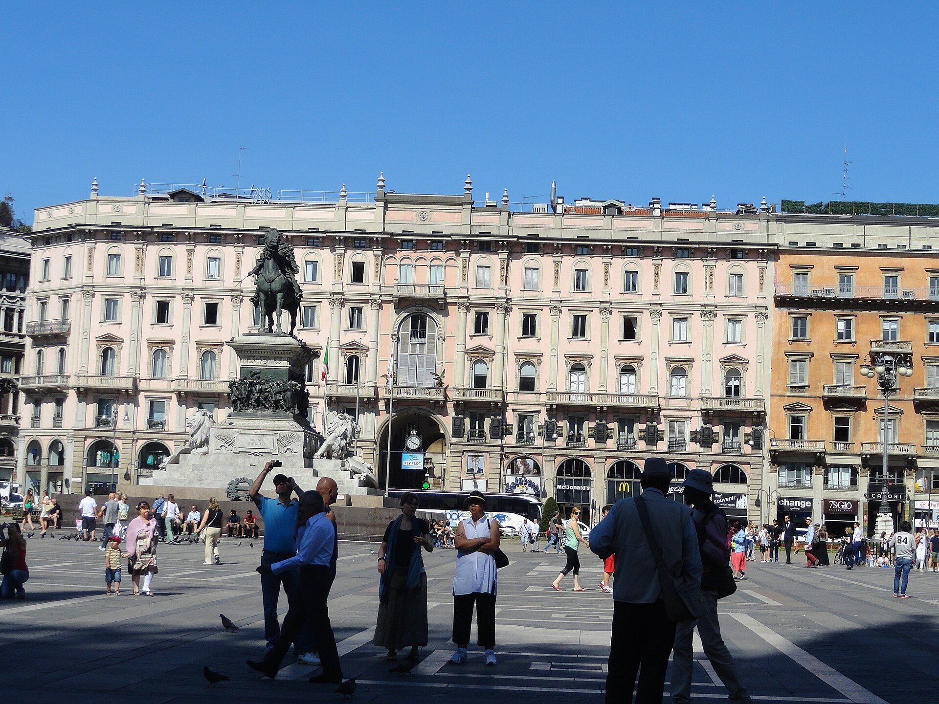 The square with the equestrian monument and crowds walking past the cathedral steps