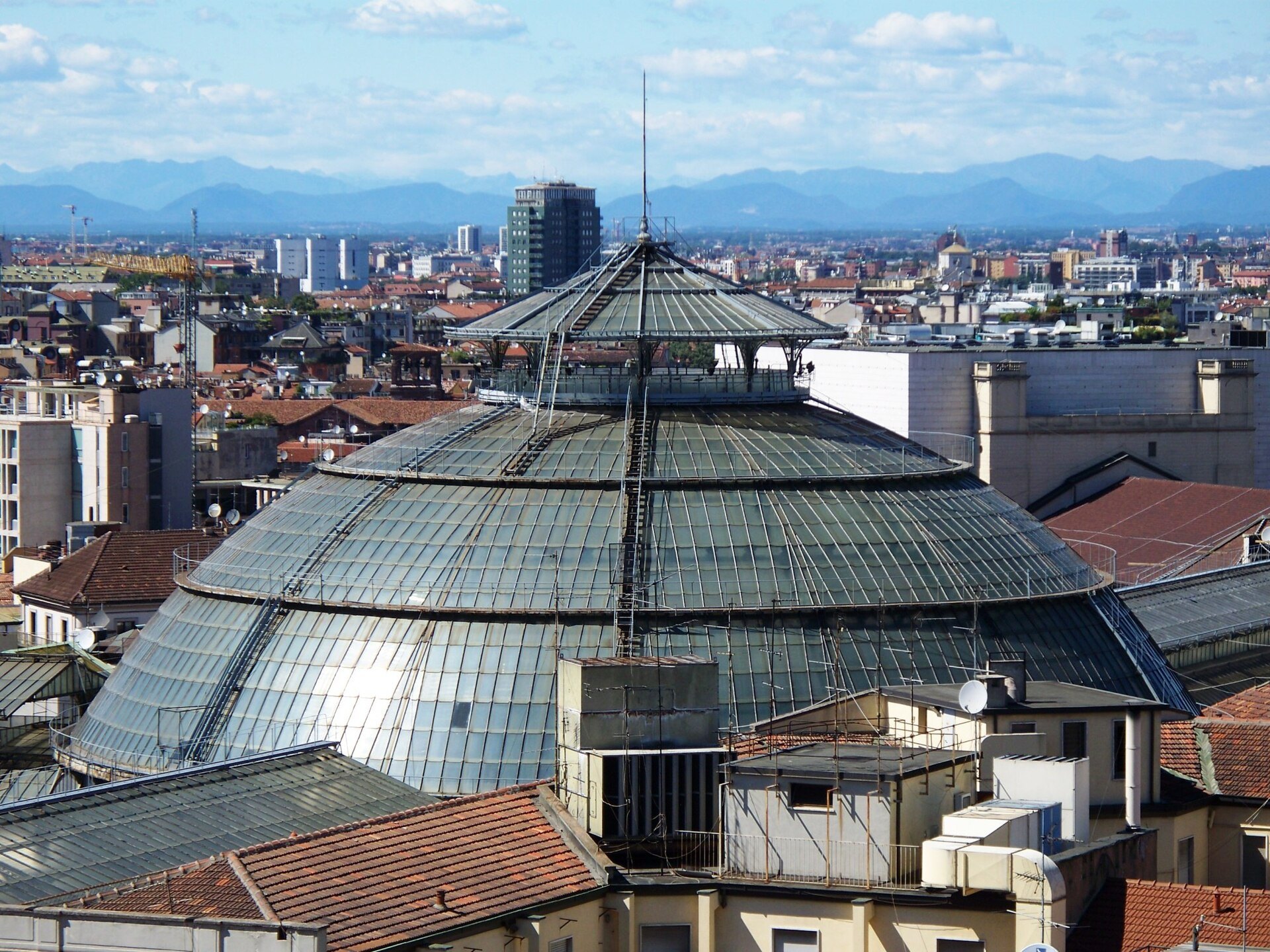 The Galleria's glass dome seen from the cathedral roof, with the city and hills beyond