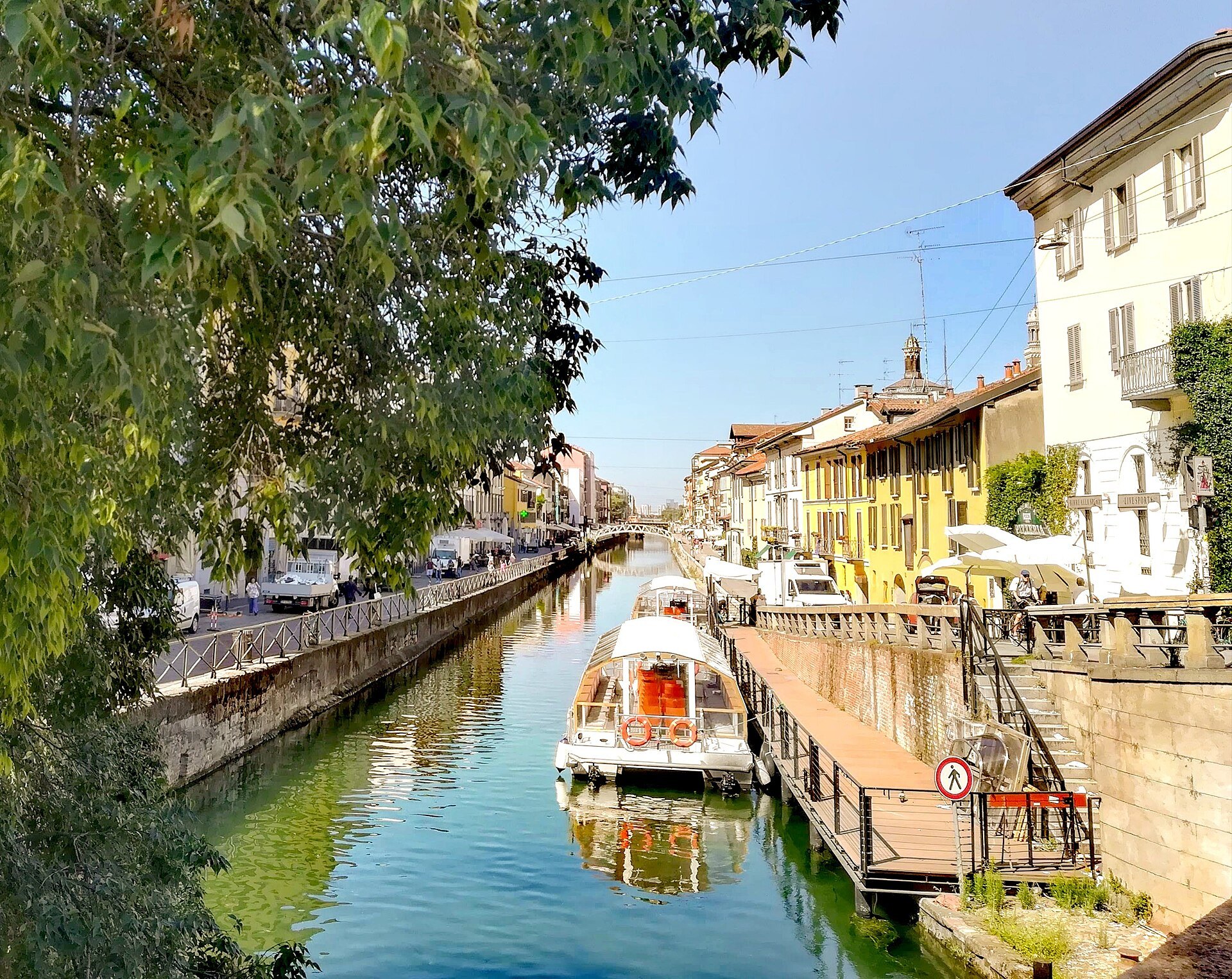 The Naviglio Grande with boats moored along it and bars lining both banks