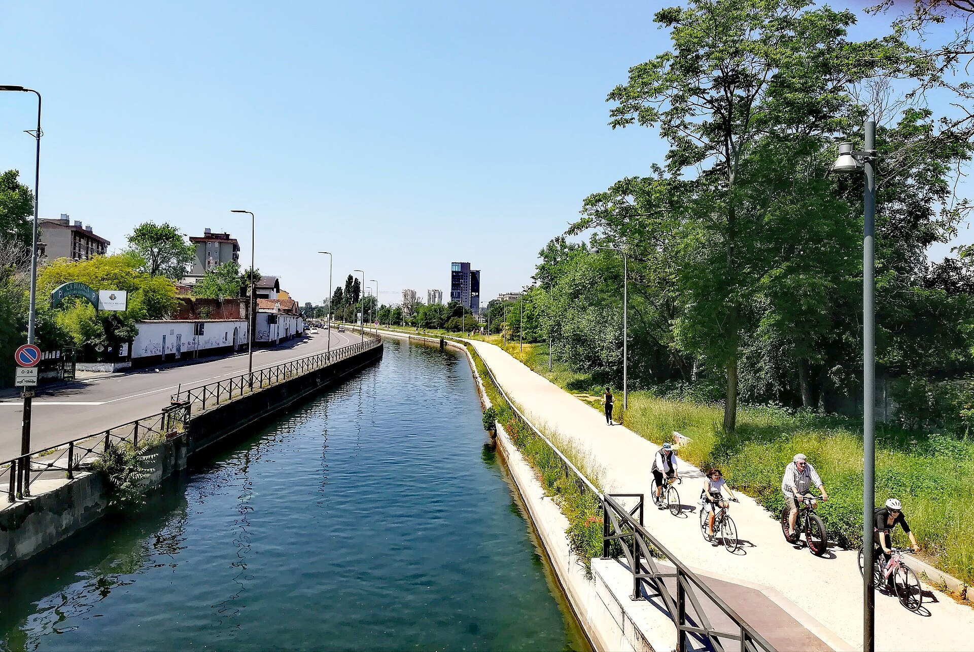 The Naviglio Grande with a cycle path and green banks on the edge of the city