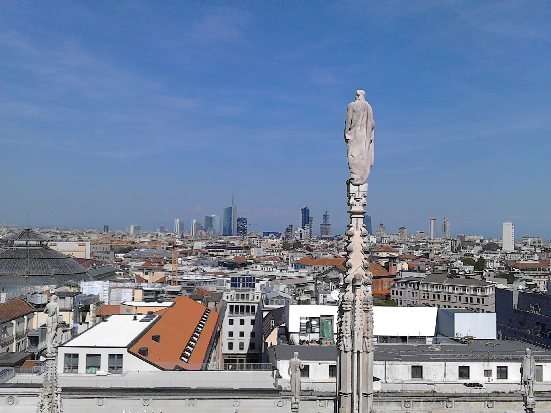 The Porta Nuova towers seen in the distance from the roof of the cathedral, past a spire