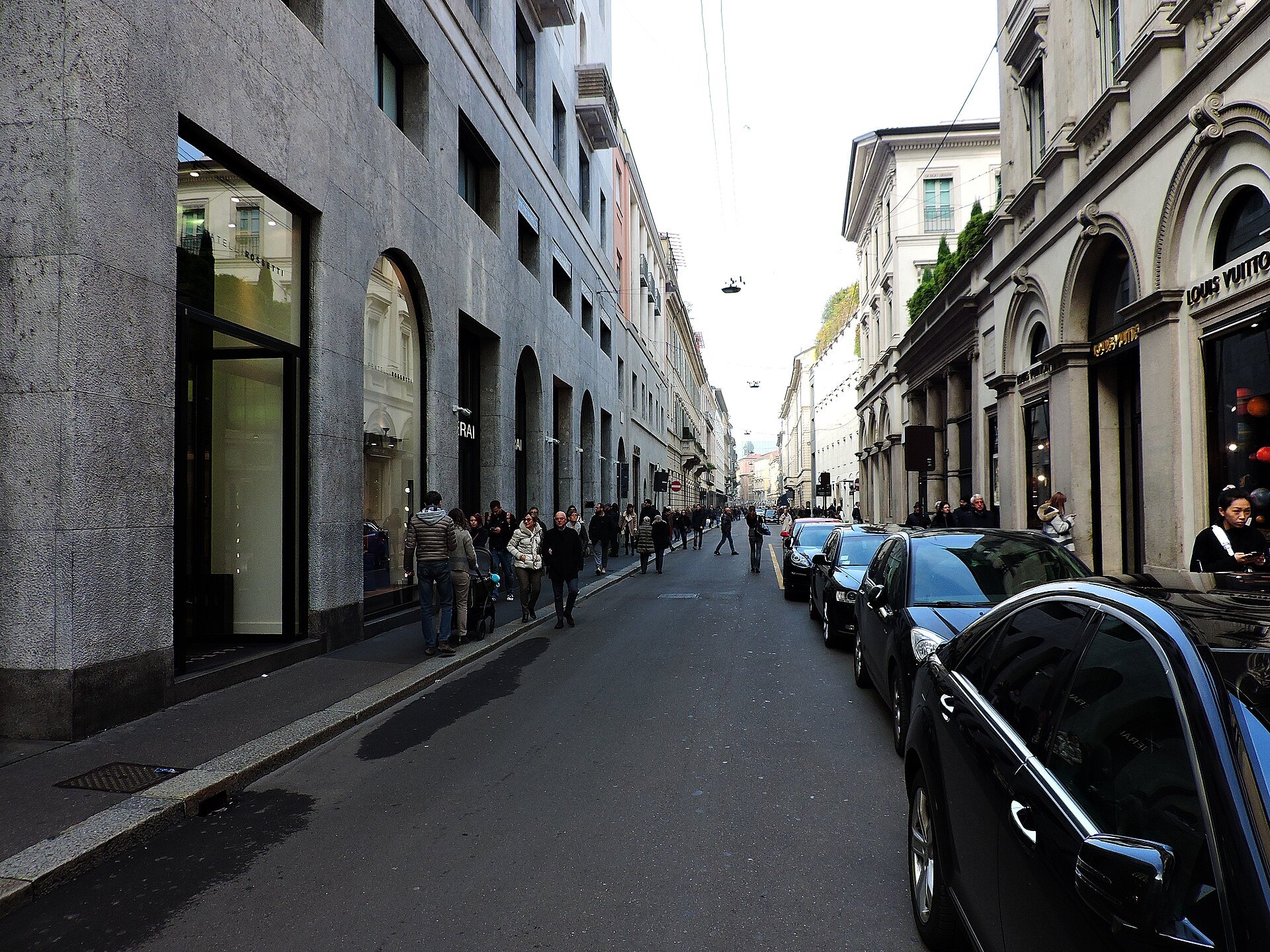 A quiet street in the Quadrilatero with parked cars and stone arcades