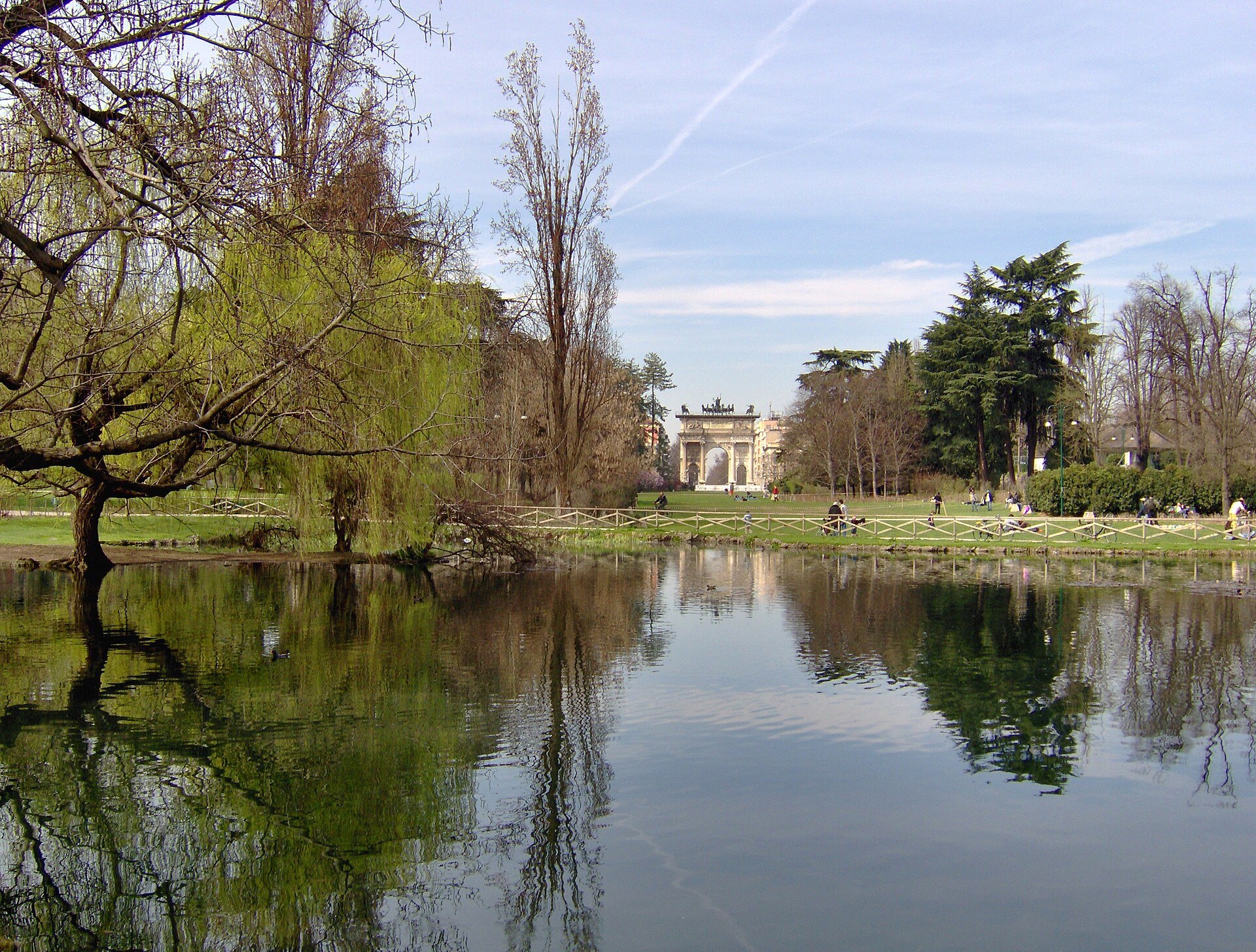 The lake in Parco Sempione with bare spring trees reflected in it