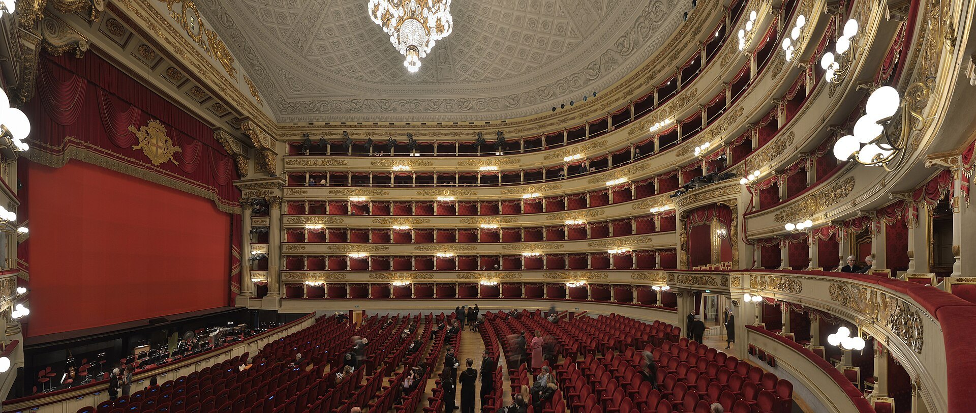 The auditorium of La Scala from a box, six tiers of red and gold boxes around the stalls