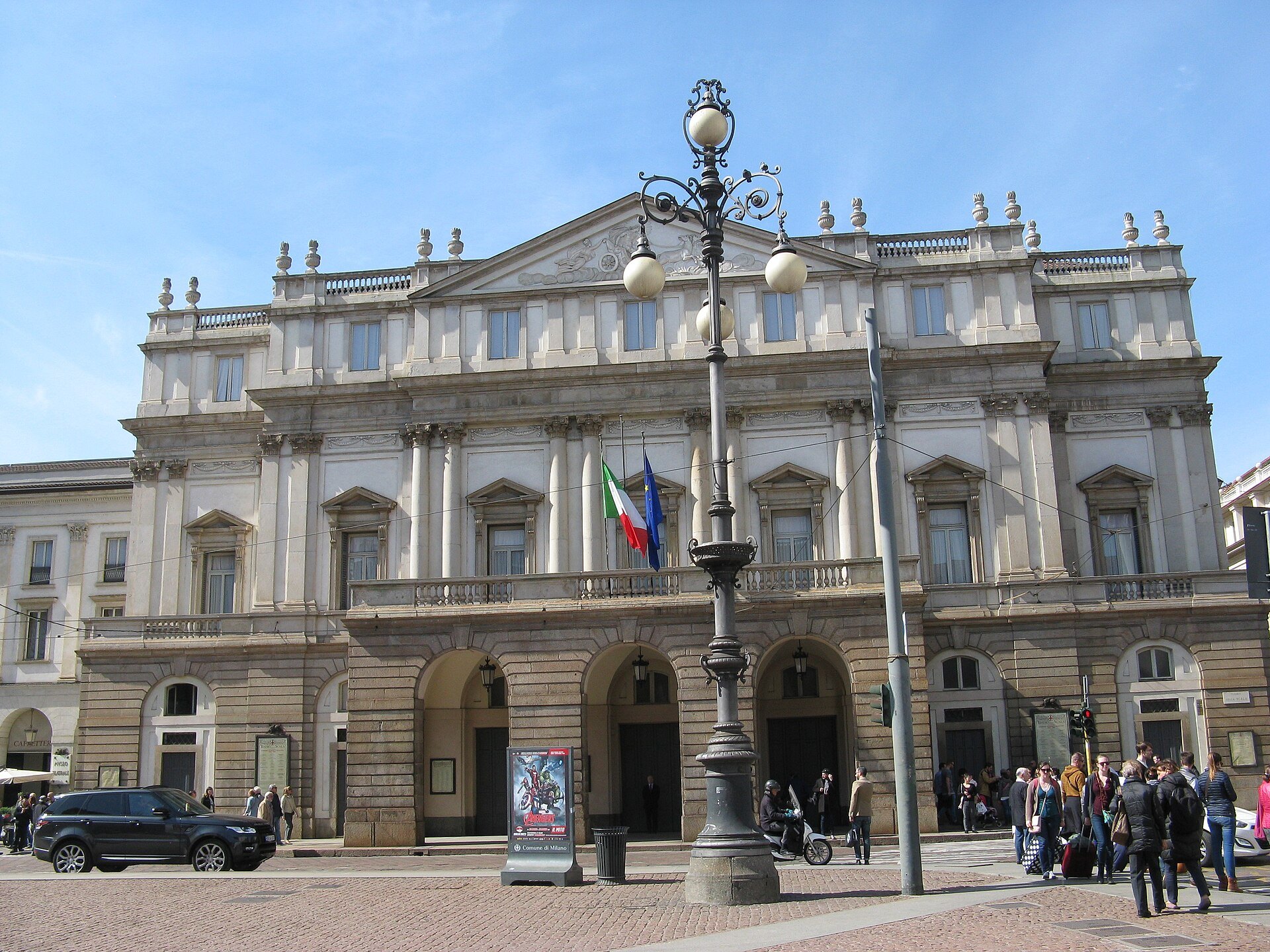 The front of Teatro alla Scala across the square with a street lamp in front of it