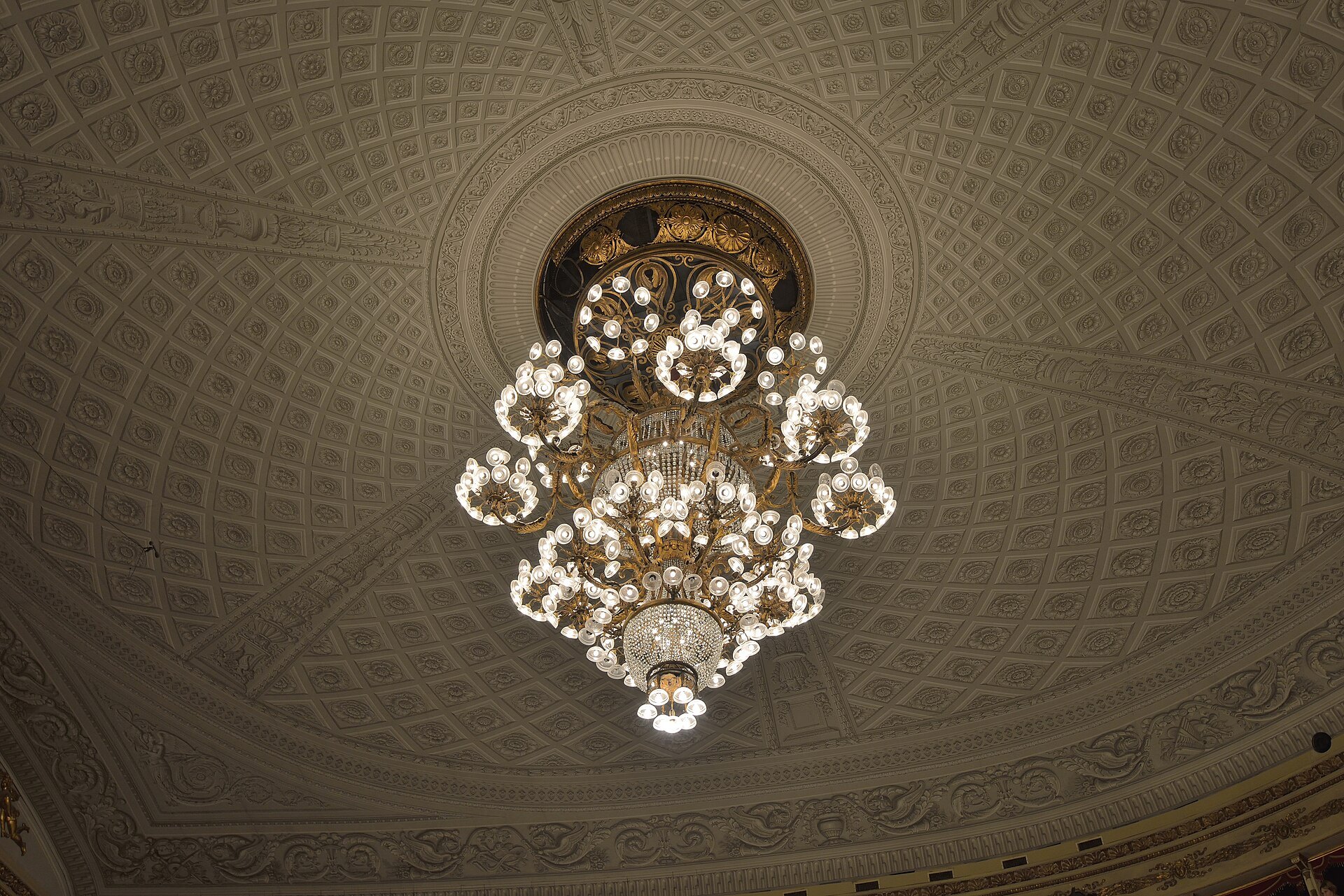 The chandelier and painted ceiling of the auditorium seen from below